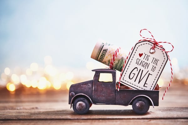 season-to-give-truck-carrying-roll-of-dollars-with-holiday-background-picture-id1166729754
